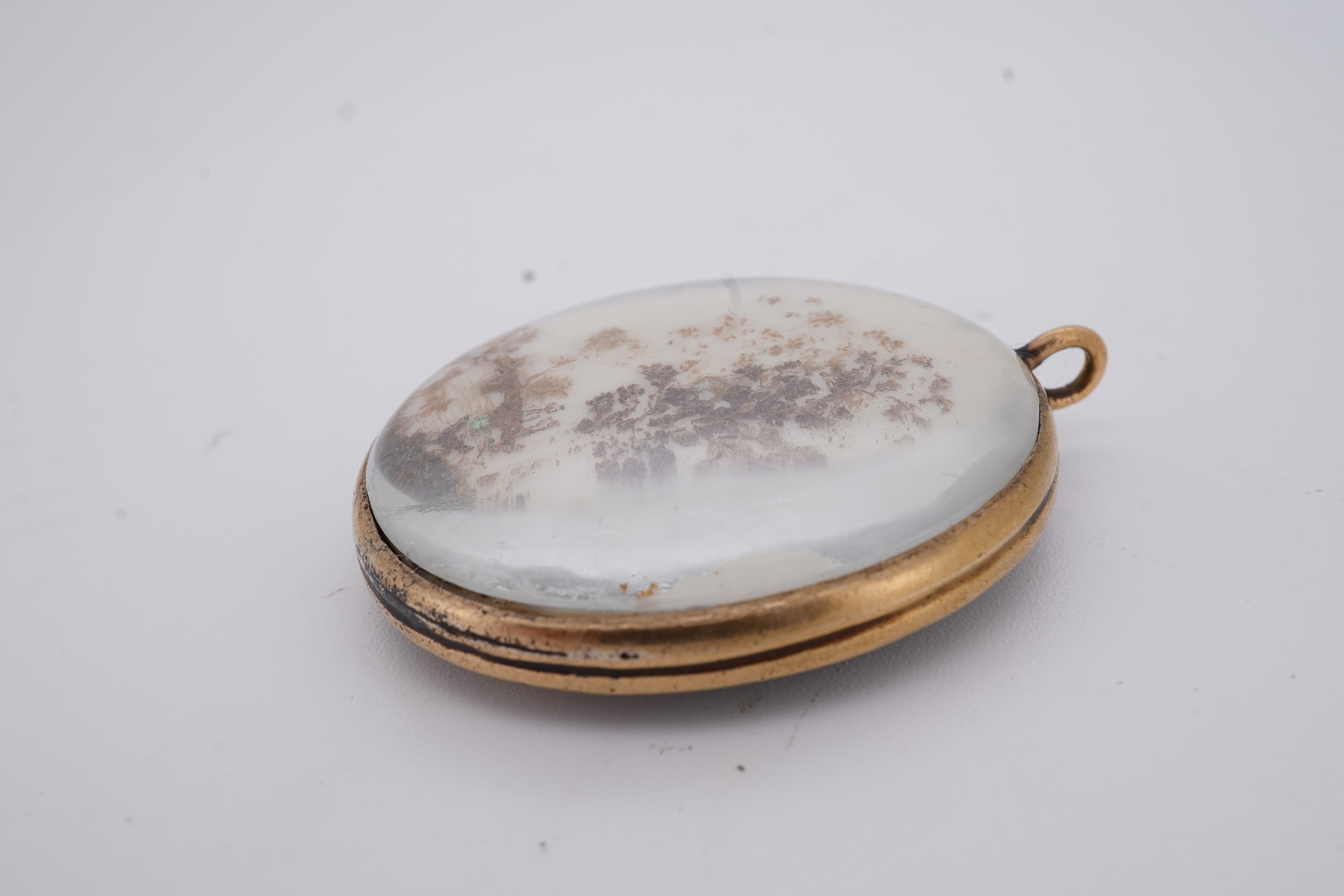 A 19th century gilt framed oval miniature watercolour portrait of a gentleman, on ivory, verso decorated with hair, depicting a landscape scene with a large tree, animals and a house, 36mm. CITES Submission reference, WU